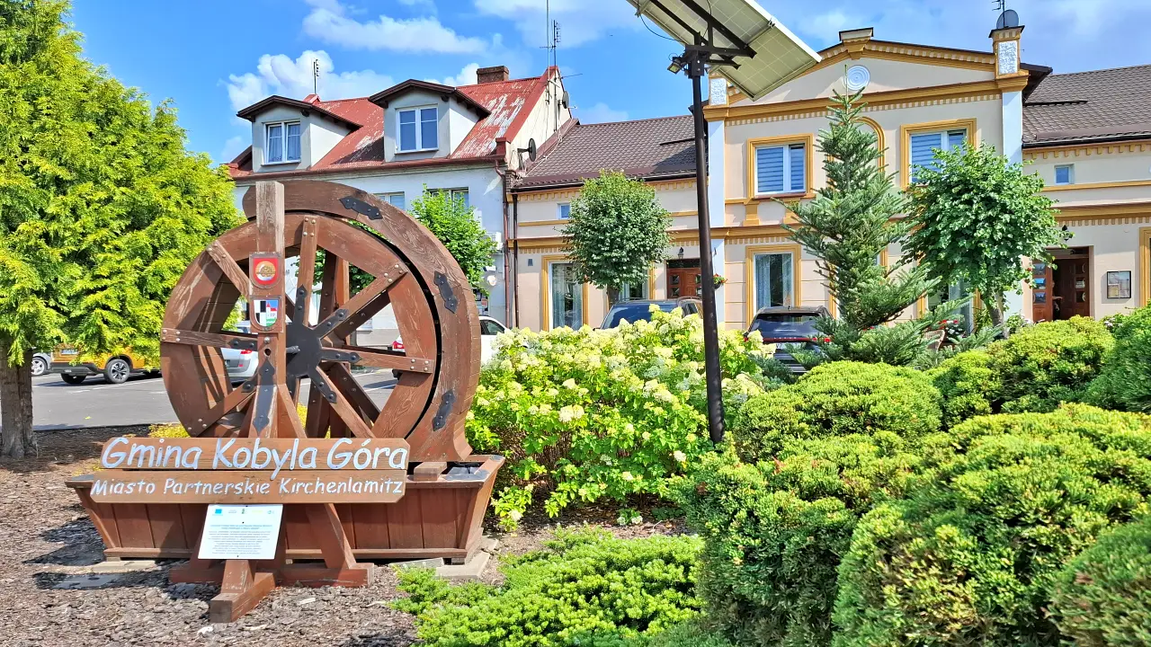 Centrum Kobylej Góry z symbolem gminy i zadbaną zielenią.